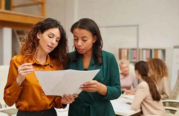 2 female students going through the list of available courses for selection