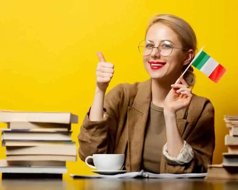 Girl giving thumbs up while waving Italian flag